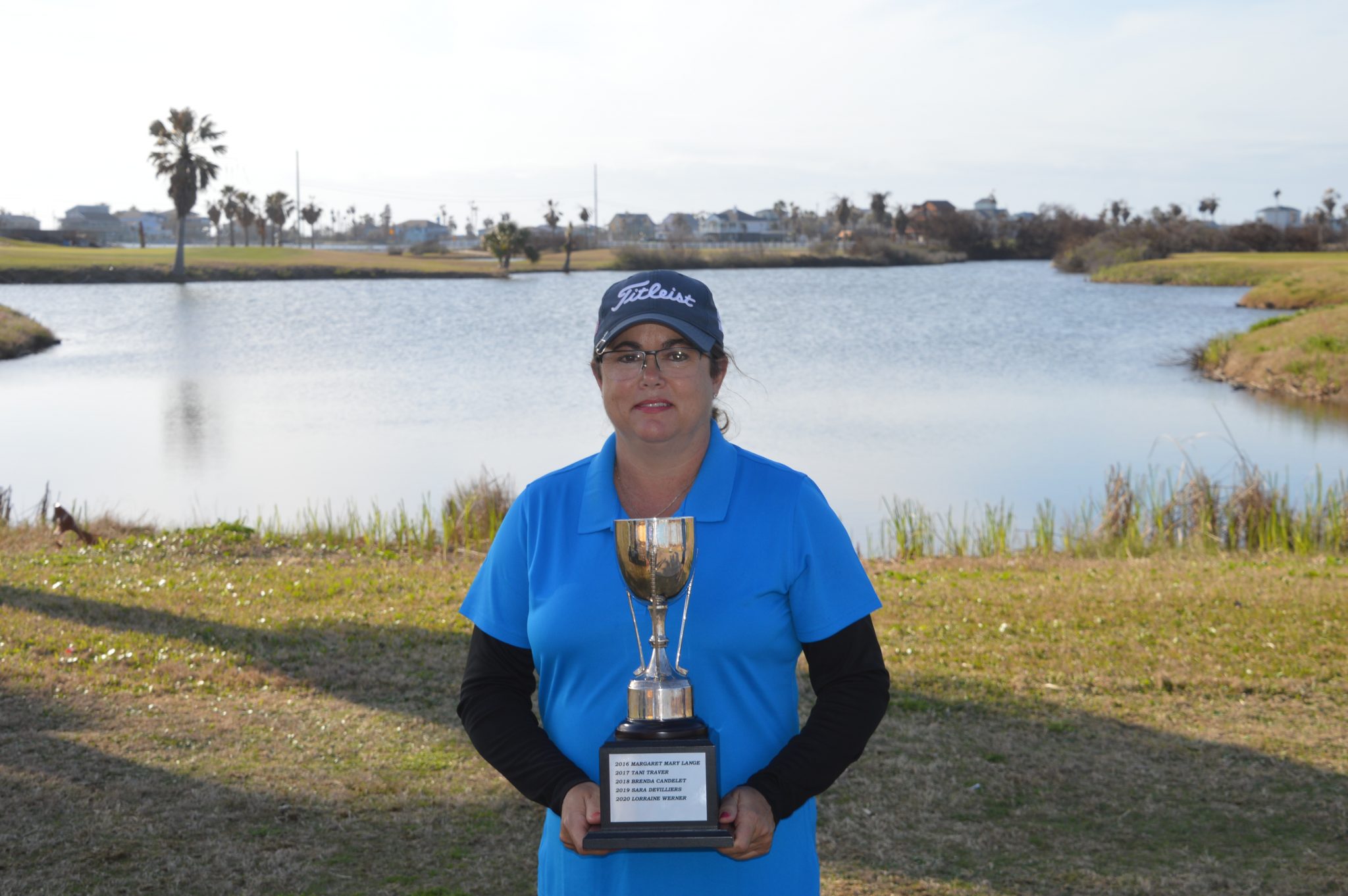 women holding trophy at golf course